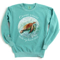 Seafoam colored sweatshirt with my artwork of a sea turtle with text reading "ocean waves make my heart smile" added to design. 