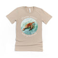 Seafoam colored t-shirt with y artwork of a sea turtle with text reading "ocean waves make my heart smile" added to design. 