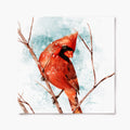 A print of a red cardinal perched on a branch with a snowy background.